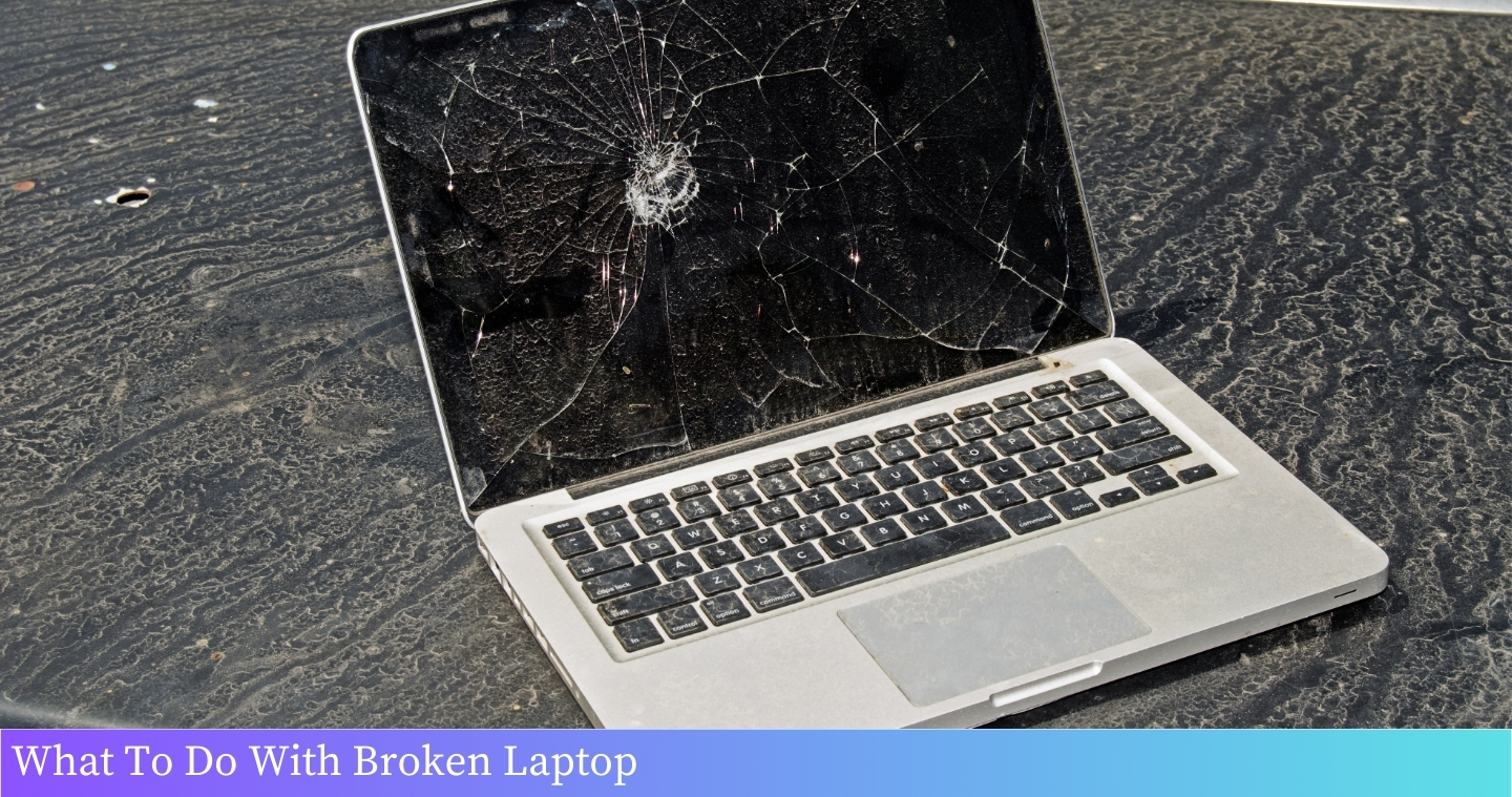 A broken laptop lying on a table, showing its damaged screen and keyboard.